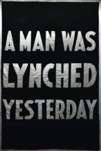 A black poster reading “A man was lynched yesterday” in thick white capital letters.