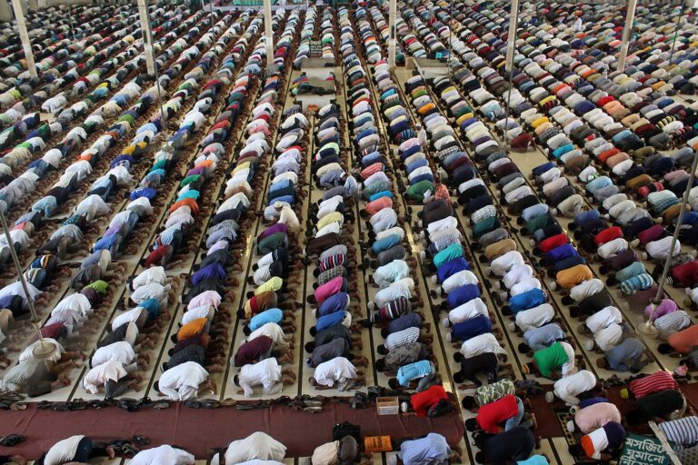 A large group of Muslims in a mosque during prayer.