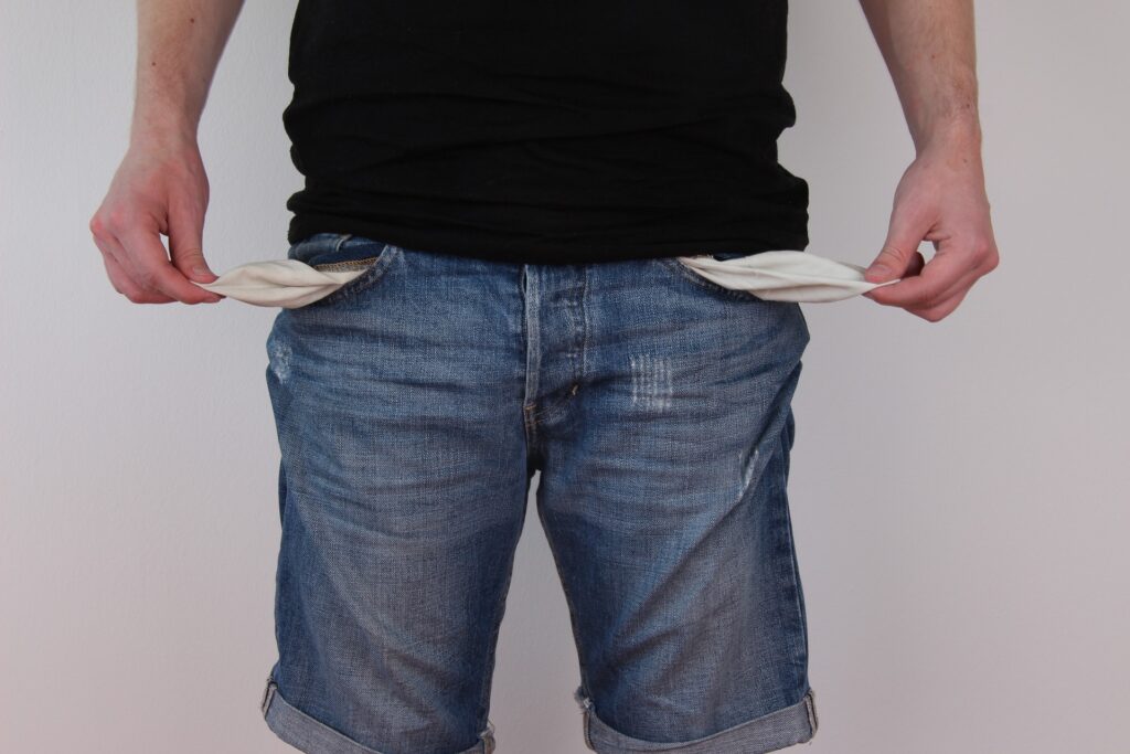 A man with his empty pants pockets turned inside out.