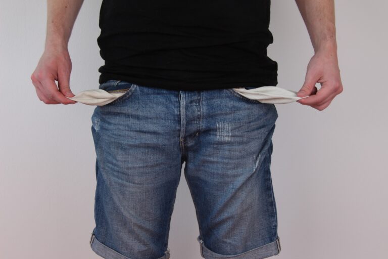 A man with his empty pants pockets turned inside out.