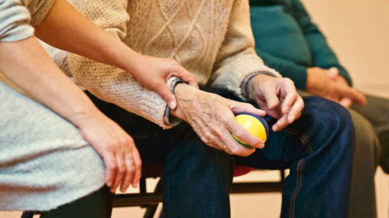 An elderly person holding a stress ball.