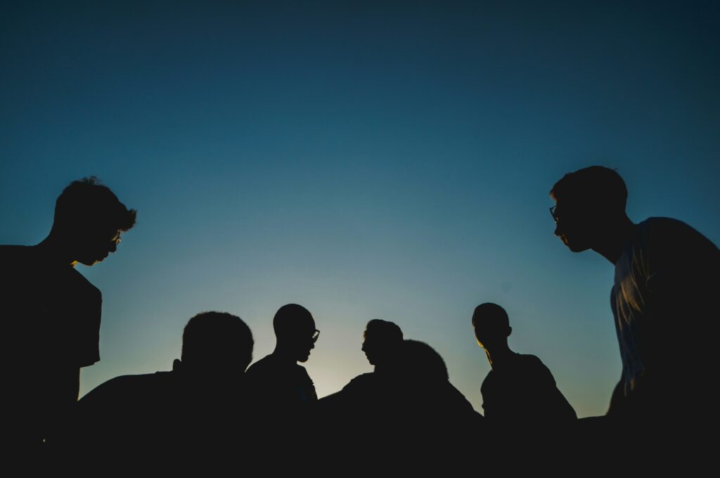 A group of people hanging out after sunset.