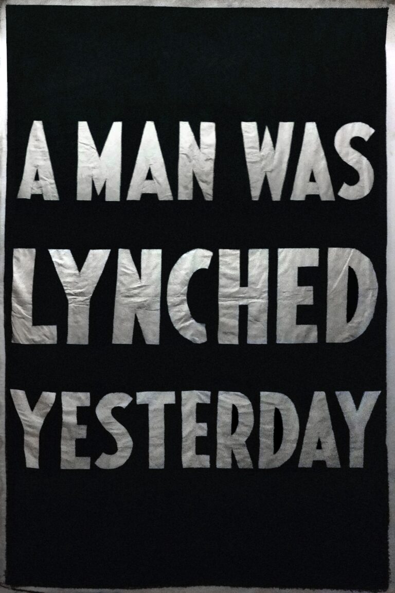 A black poster reading “A man was lynched yesterday” in thick white capital letters.